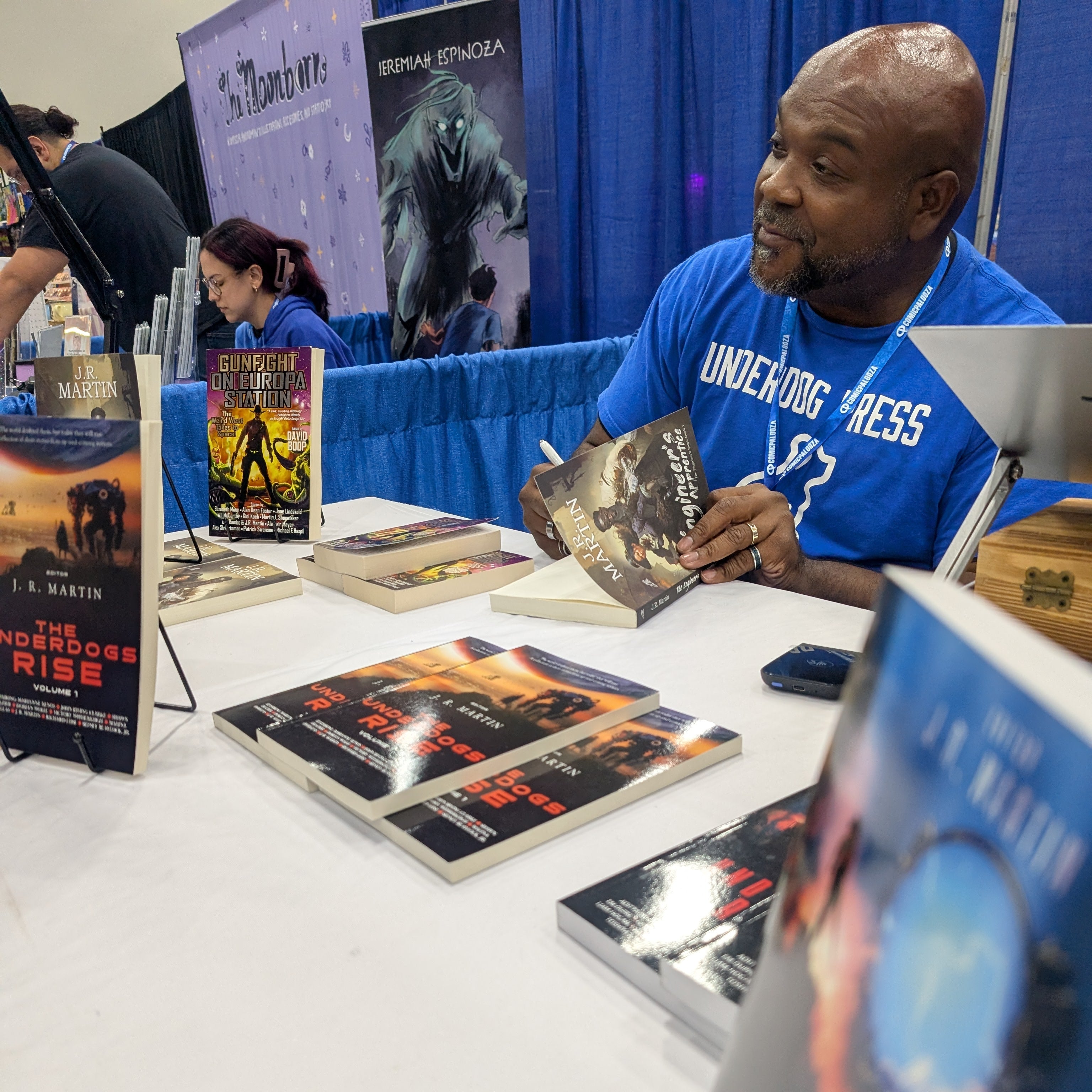 J. R. Martin signing books at a table with book covers displayed
